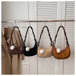 Detail of hobo crescent bags with braided rope straps and plush pompom charms