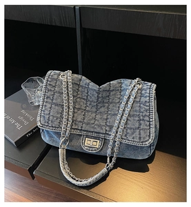 Détail du sac en jean matelassé avec bandoulière chaîne argentée et fermoir pivotant