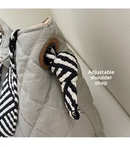 Detail of quilted tote bag featuring adjustable black and white striped rope straps