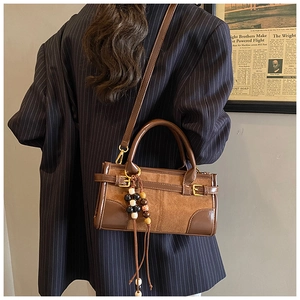 Dettaglio della borsa in pelle scamosciata vintage marrone con nappine di perle