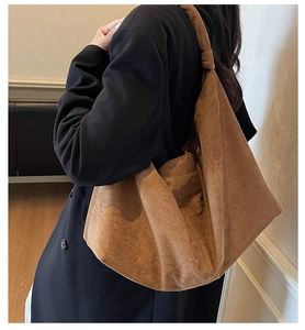 Detail of a brown suede hobo bag with unique knotted strap and large capacity
