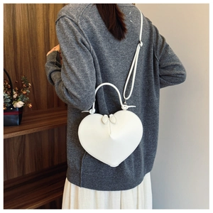 Borsa a tracolla bianca a forma di cuore indossata da una modella sul retro