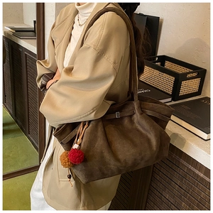 Détail du sac cabas mat marron foncé avec pompon en fourrure et fine bandoulière