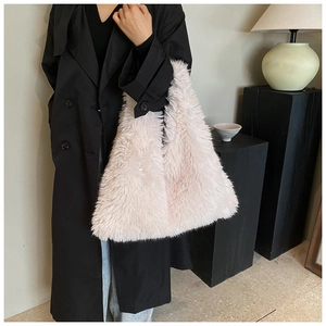 Close-up of light pink plush faux fur tote bag showing soft texture and shoulder carry style