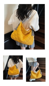 Detail of yellow quilted tote bag with striped woven strap and knot decoration