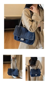 Detail of dark blue denim chain bag featuring diamond quilted stitching and silver clasp