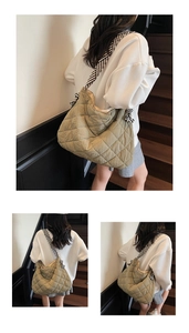 Close-up of quilted large tote bag with striped shoulder strap and khaki padded texture