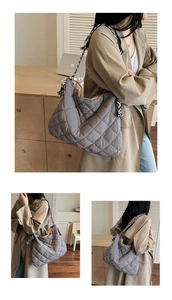 Detail of grey quilted tote bag featuring stylish black and white striped straps