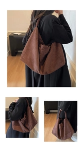 Detail of a large brown suede tote bag with a soft texture and wide shoulder strap