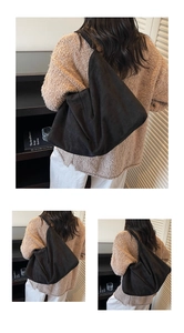 Detailed back view of a minimalist black suede hobo bag worn with a knit sweater