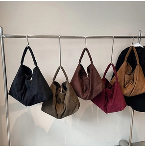 Hobo style suede shoulder bags in five colors hanging on a minimalist display stand