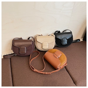 Detalle de bolsos tipo montura en marrón, beige y negro con texturas mate y hebilla