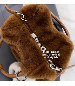Detailed close-up of the silver hardware zipper pull on the brown faux fur shoulder bag