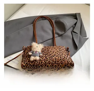 Detalle del bolso tote con estampado de leopardo, textura de felpa y colgante de osito