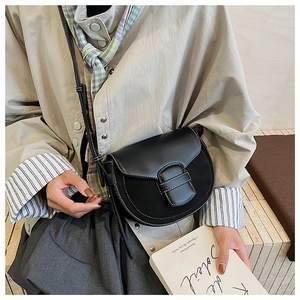 Detalle del bolso de silla negro con pespuntes blancos y diseño de patchwork