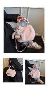 Detailed view of pink plush crossbody bag with leather handles and grey bunny charm
