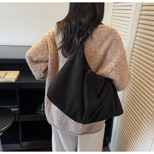 Detail view of the wide shoulder strap and matte texture on a large black hobo bag