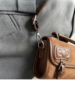 Detail view of brown suede Boston bag showing silver hardware and leather trim