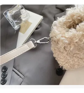 Detail of silver lobster clasp and leather strap on a soft faux shearling handbag