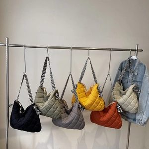 Quilted nylon tote bags with striped straps in multiple colors on a metal hanger