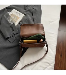 Internal view of brown crossbody bag showing spacious capacity for phone and makeup