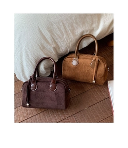 Close-up of suede bowling bags with leather tassels and metallic bead details