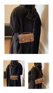 Detail showing the retro brown boston bag with decorative buckles and textured finish