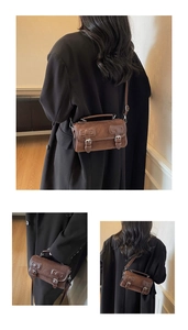 Detail view of vintage brown matte boston bag featuring silver metal buckle fasteners