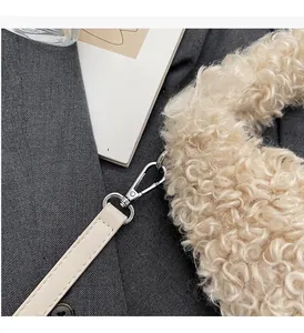 Macro detail of cream faux fur handle and silver metal clasp on the fashion shoulder bag