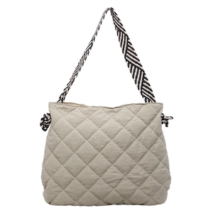 Quilted light gray-green tote bag with diamond lattice pattern and geometric strap