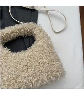 Detailed close-up of soft beige faux shearling texture and chic crossbody strap design