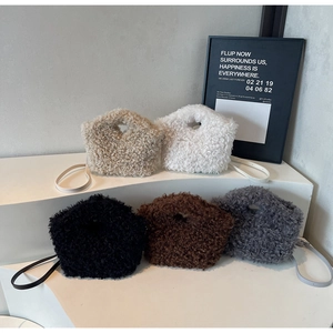 Detailed view of plush faux fur handbags in five neutral colors on display stands