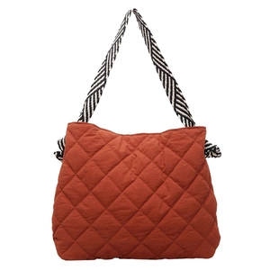 Quilted brick red tote bag with stylish black and white striped woven shoulder strap