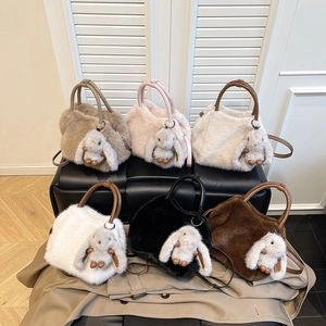 Chic plush tote bags in six colors with bunny charms and leather handles on a bench