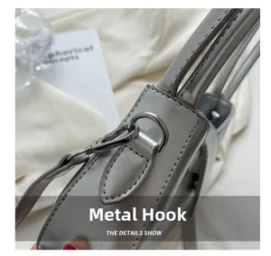 Detail of silver metallic swivel hook and D-ring on chic faux leather shoulder bag