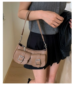Detail einer braunen Hobo-Tasche mit Doppeltaschen, Schnallen und eleganter Lederstruktur