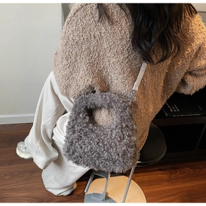 Detail of grey plush mini handbag with textured faux fur and integrated circular handle