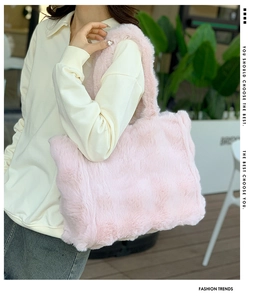 Toma exterior de un bolso tote de piel sintética rosa llevado por una modelo con ropa casual