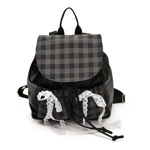 Fashionable black leather backpack with plaid flaps and white lace bows in a preppy style