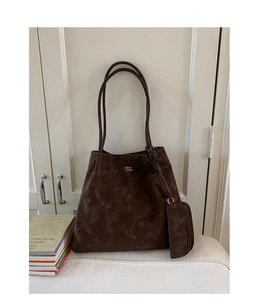 Detail of coffee brown tote bag showing matte texture and mini zipper pouch attachment