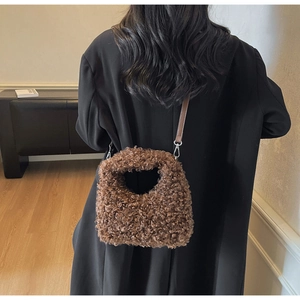Close-up of fluffy dark brown teddy wool texture and leather strap on a stylish handbag