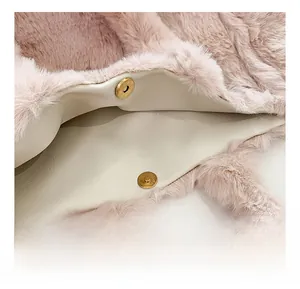 Primer plano detallado del bolso de peluche rosa con cierre magnético metálico elegante