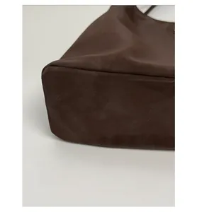 Detailed view of the reinforced sturdy base of this coffee brown tote bag for structural shape