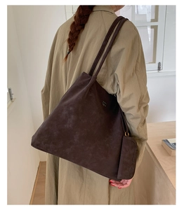 Detail view of large dark brown suede tote bag with matching inner pouch and slim straps