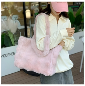 Foto callejera de un bolso tote grande de peluche rosa suave con textura de felpa