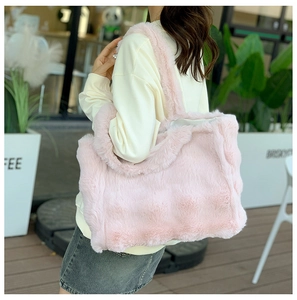 Détail d'un sac cabas en peluche rose clair montrant la texture douce et le style hivernal