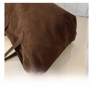 Detailed close-up of brown frosted leather fabric and stitching on this tote bag
