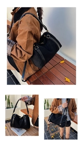 Détail du sac bandoulière en suède avec boucles dorées et lanières en cuir sur banc en bois