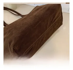 Macro detail of high-quality stitching and grainy suede texture on a vintage tote bag
