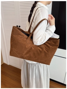 Deep brown suede large tote bag with long straps in a minimalist lifestyle setting